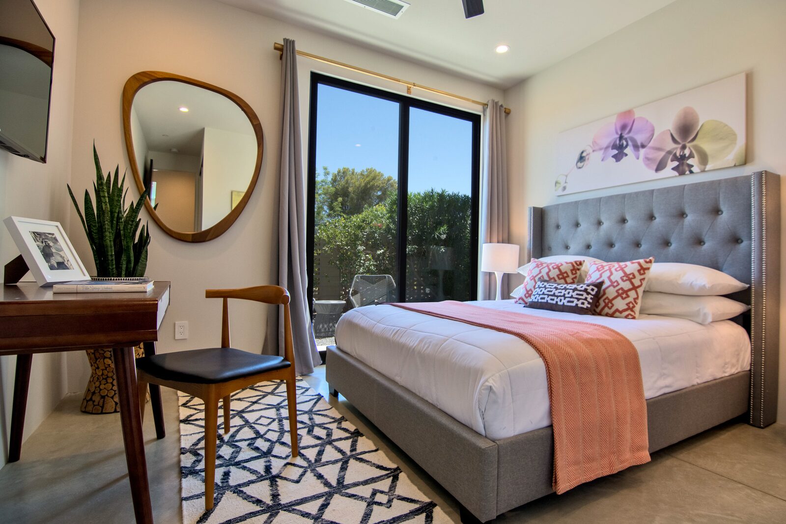 5 Palms Estate bedroom with upholstered headboard and coral accents