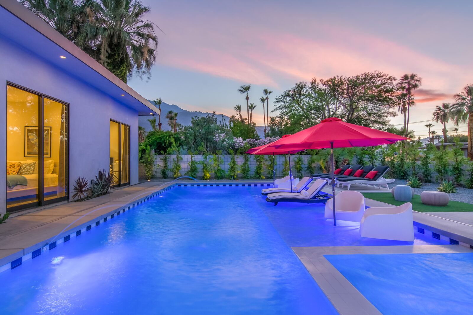 5 Palms Estate pool at blue hour with red umbrellas