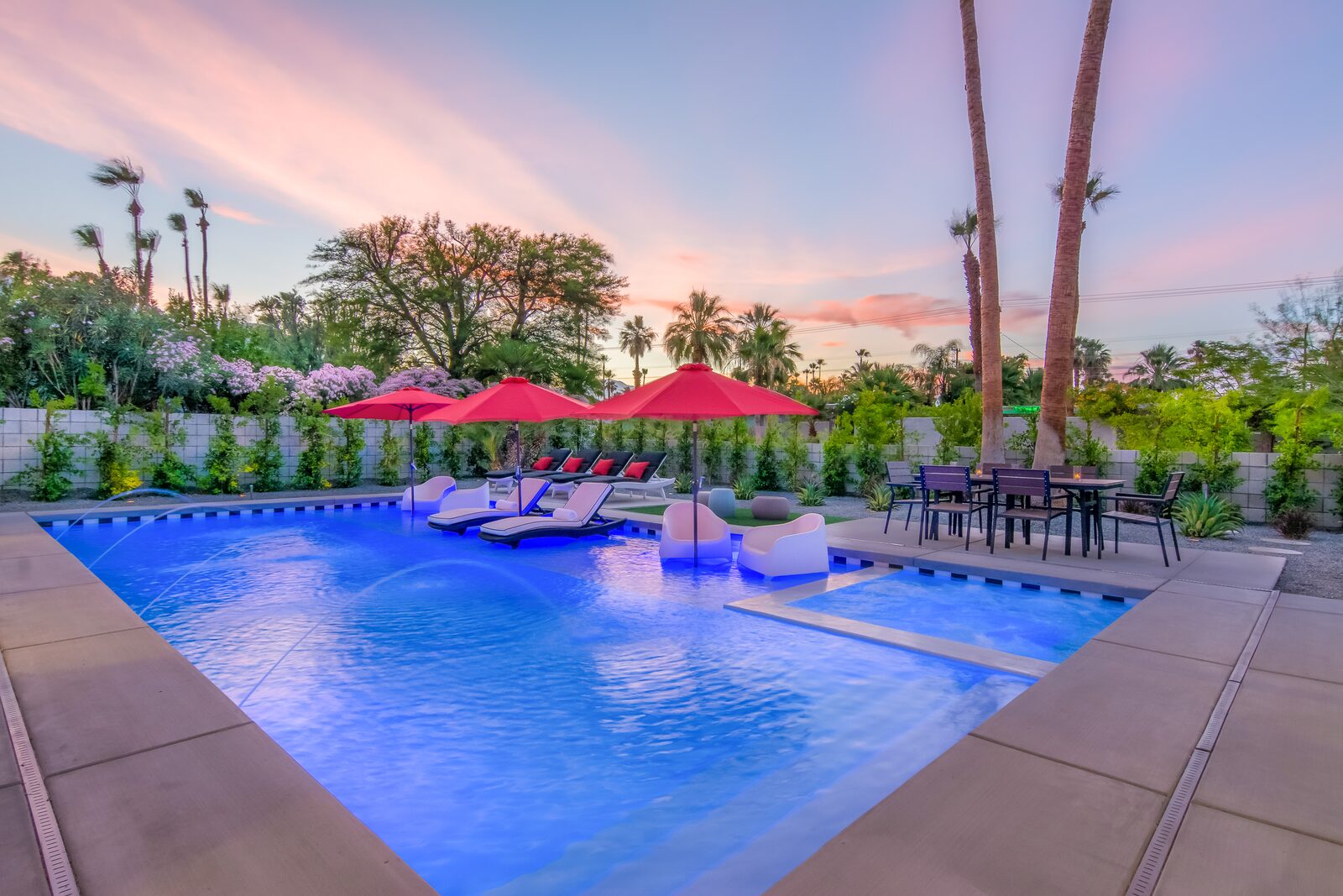 5 Palms Estate exterior at sunset with lit pool and red umbrellas