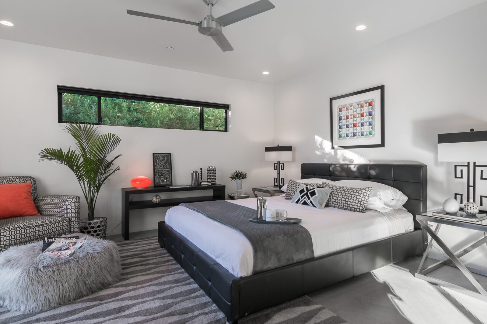 Palms at Park Villa bedroom with framed art and dark headboard