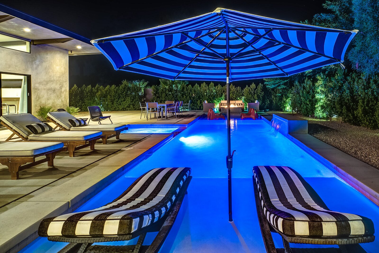 Palms at Park Villa pool at blue hour with striped umbrellas